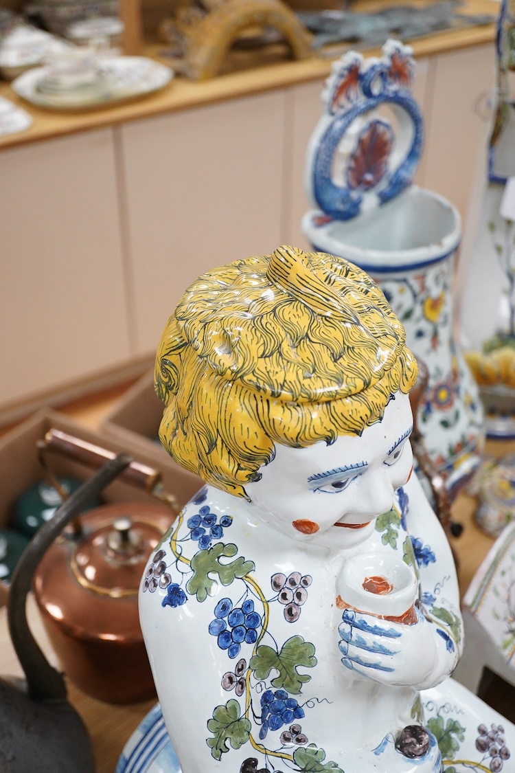 A large Brussels style faience Bacchus figural wine cistern, 62cm high